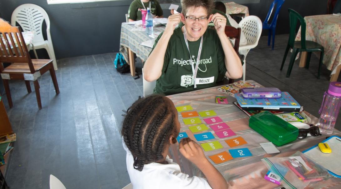 Projects Abroad volunteer teaching English spelling to a student in Belize A young girl learns the alphabet during at a volunteer teaching placement in Belize